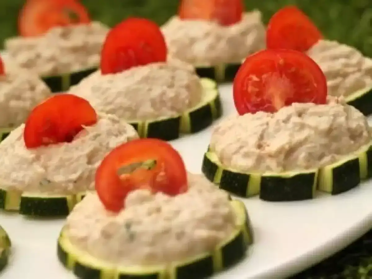 Petits toasts de rillettes de thon crème fraîche sur rondelles de courgette, garnis d'une tranche de tomate.