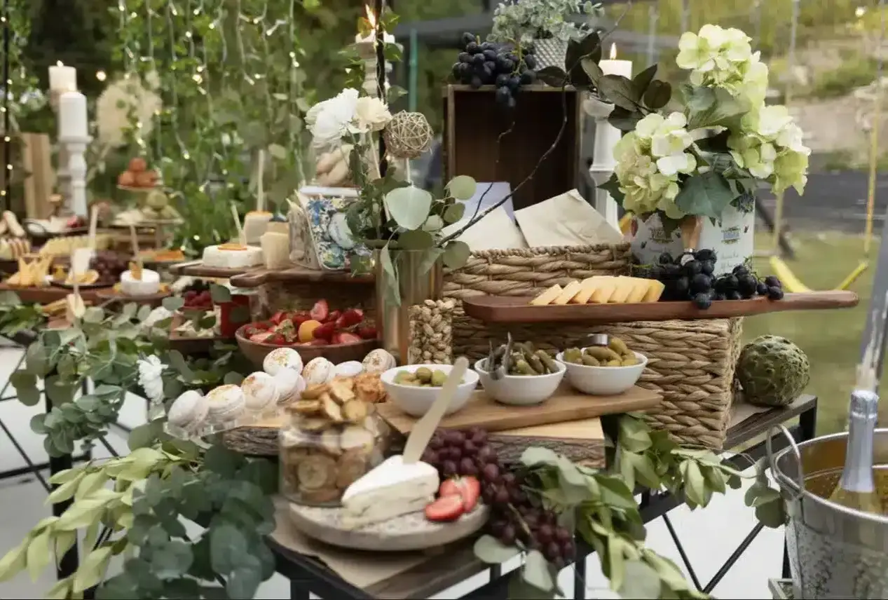 Un magnifique repas champêtre pour 50 personnes, avec un buffet garni de fromages, fruits, olives, macarons et champagne.