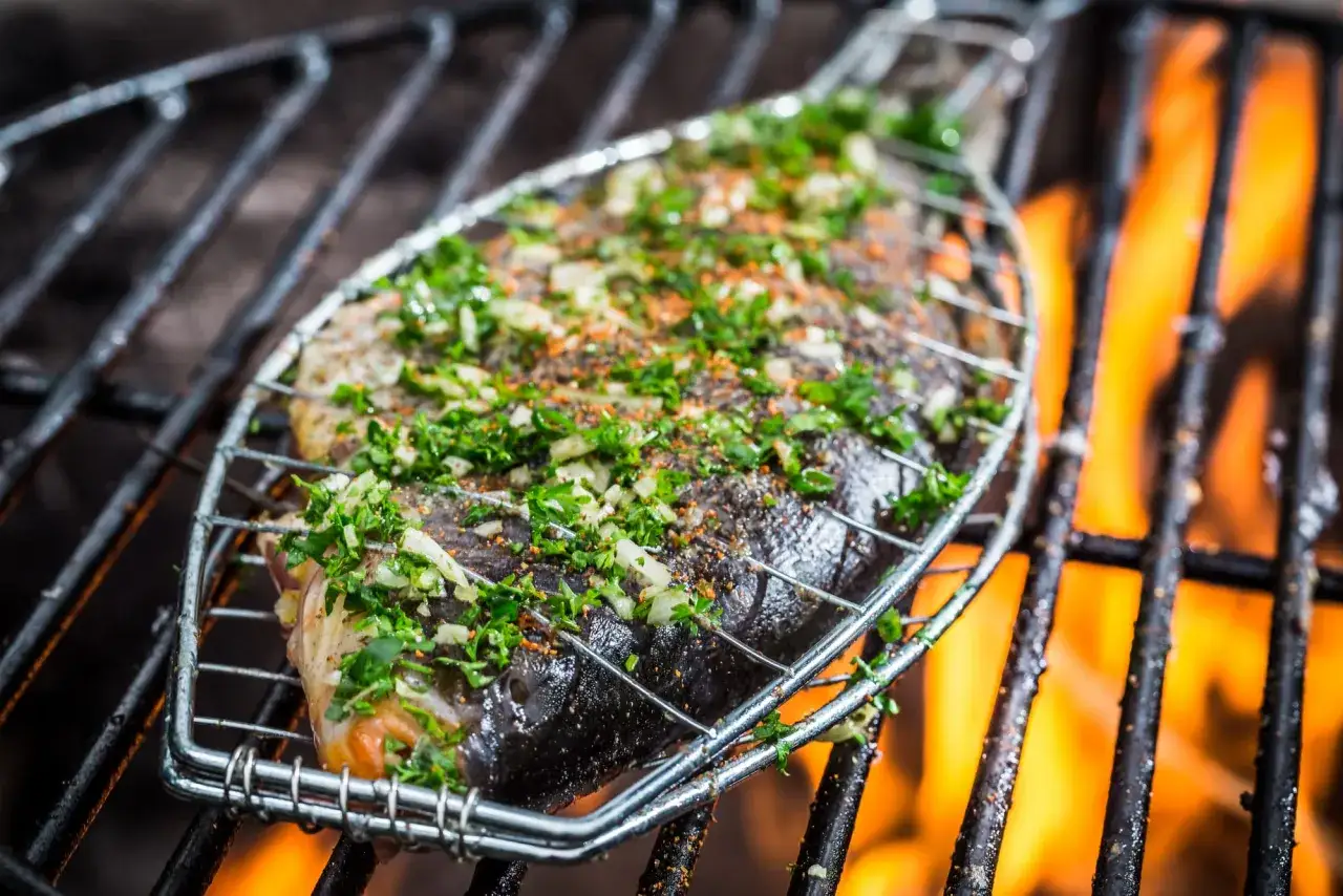 Poisson entier assaisonn&eacute; d'herbes et d'&eacute;pices, cuisant sur un barbecue. Un d&eacute;lice de barbecue poisson et crustac&eacute;s.