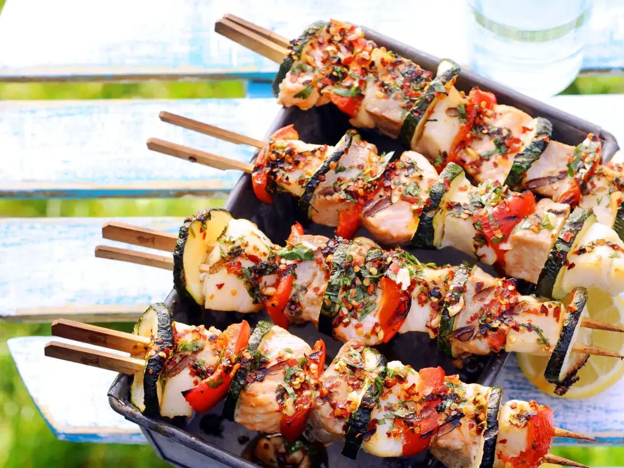 Brochettes de poisson grillées avec courgettes et tomates, assaisonnées d'épices. Un accompagnement parfait pour un repas estival.