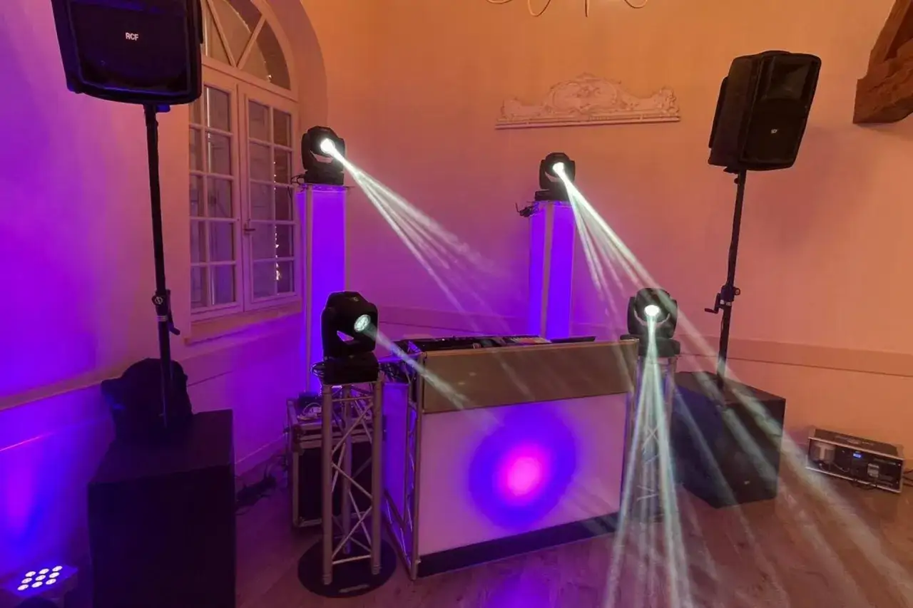 Matériel de DJ prêt pour un mariage. Spots lumineux, enceintes et console DJ créent une ambiance festive. Le prix du DJ de mariage inclut cette installation.
