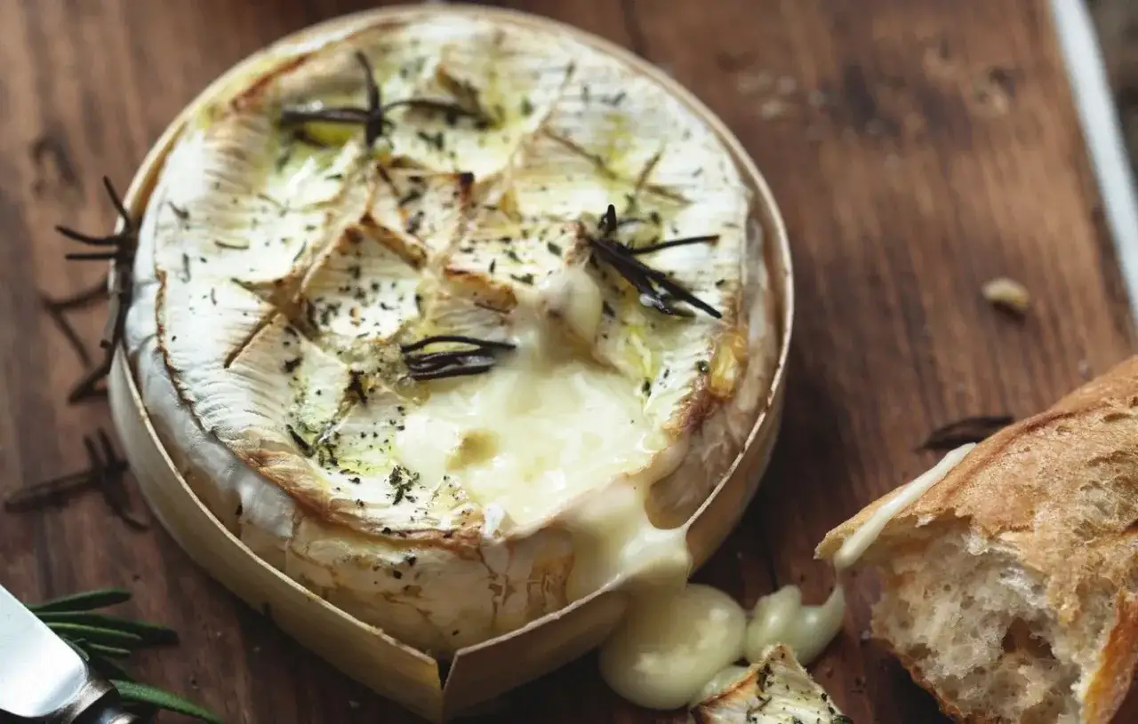Coulommier au barbecue, fondant et parfumé, prêt à être dégusté avec une baguette croustillante.
