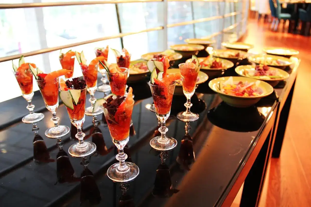 Cocktail de bienvenue mariage : de petits verres remplis de crevettes et de concombre, prêts à être dégustés.
