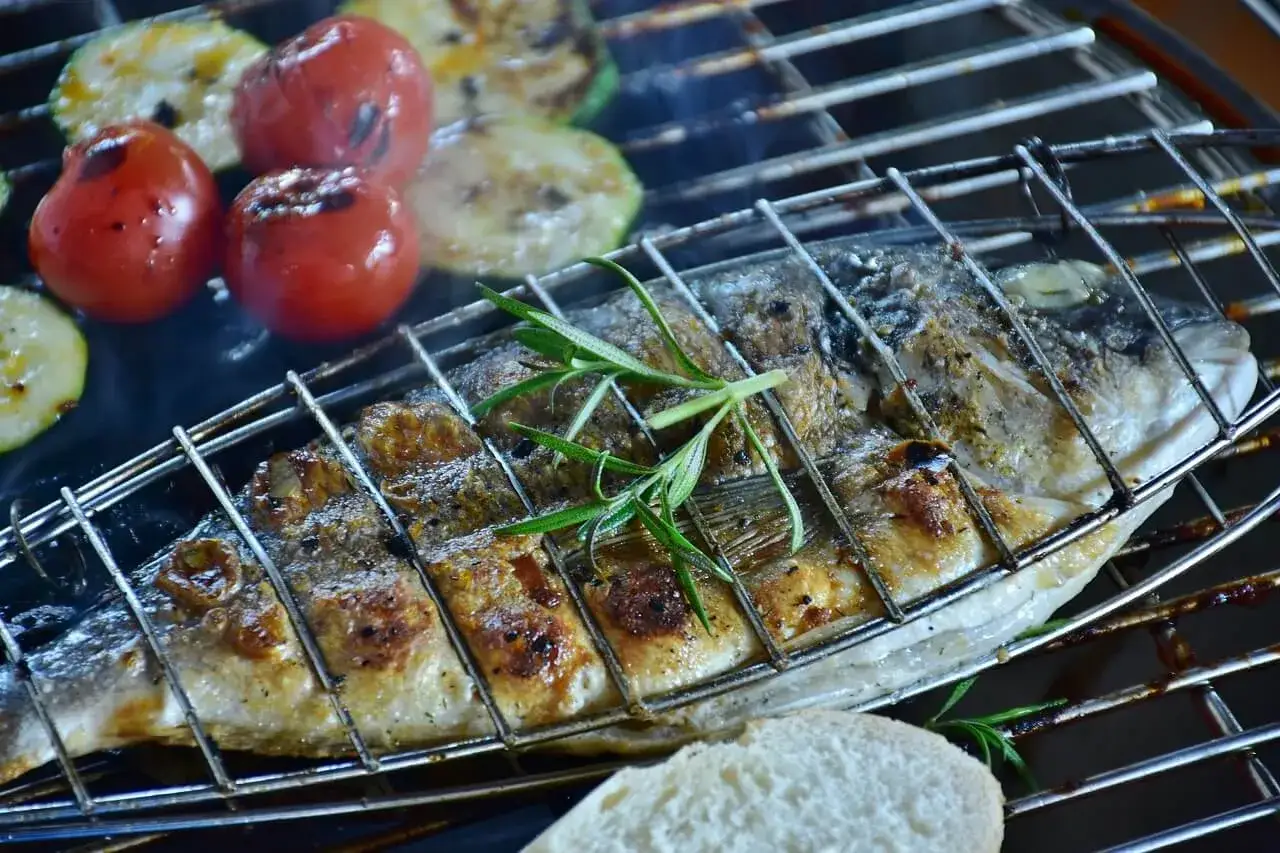 Dorade grillée sur le barbecue, avec tomates et courgettes. Le temps de cuisson dorade barbecue est presque parfait.