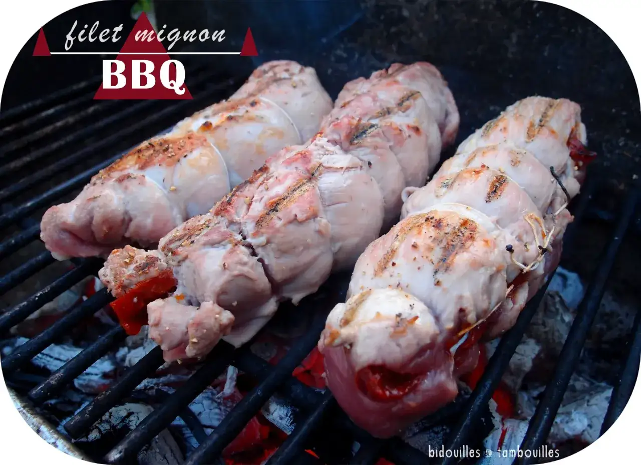 Trois filets mignons farcis au barbecue, prêts à être grillés sur des braises ardentes.