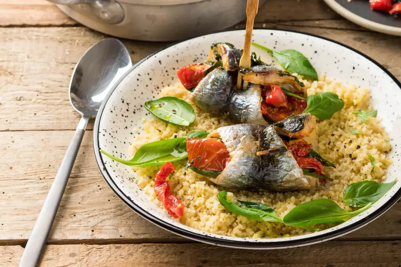 Sardines farcies aux tomates sur lit de couscous. Faut-il écailler les sardines ? Ici, elles semblent prêtes à être dégustées.