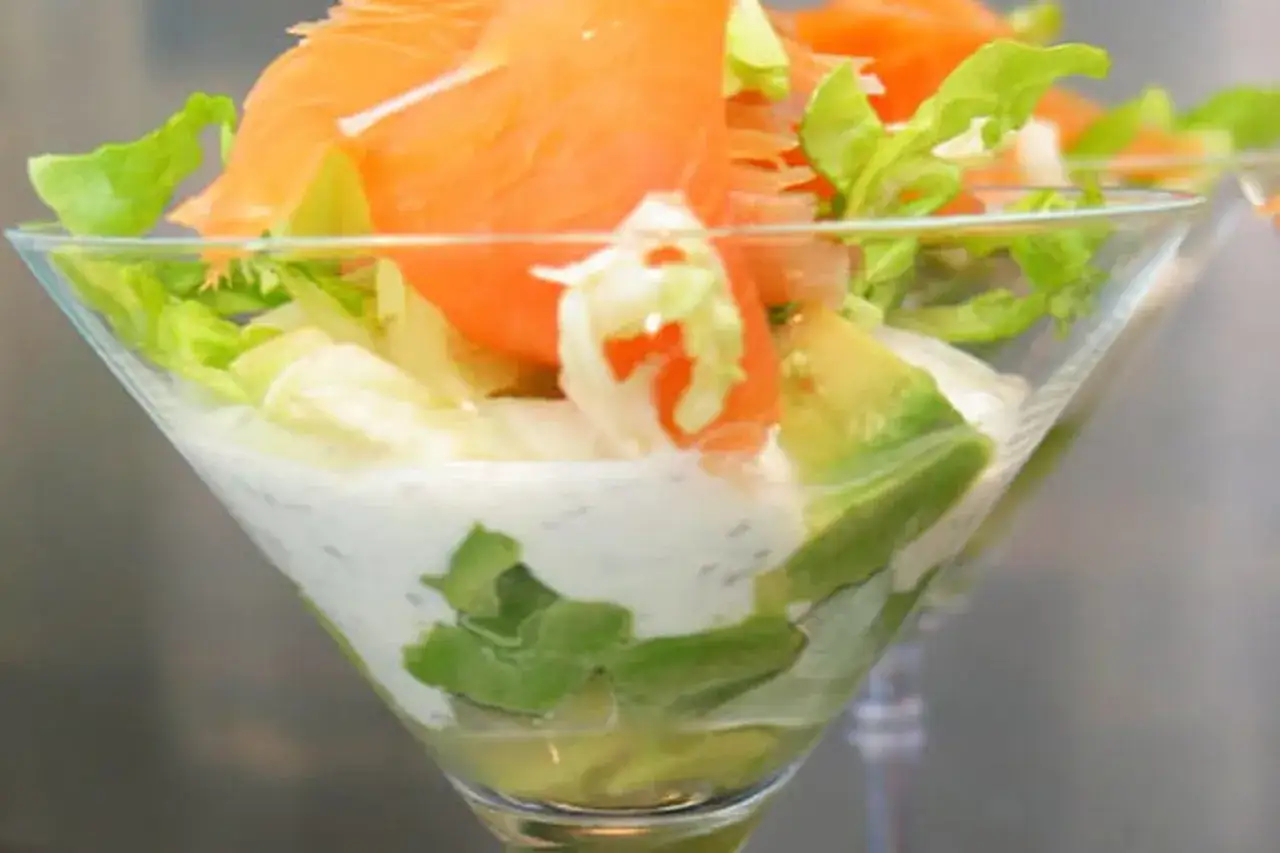 Salade de saumon fumé, avocat et laitue dans un verre à cocktail. Une recette d'entrée de mariage parfaite pour un repas élégant.