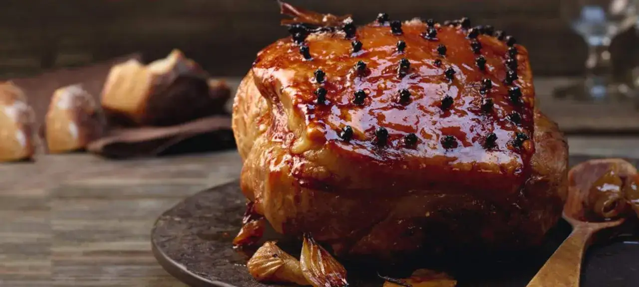 Un succulent cochon de lait farci, glacé et parsemé de clous de girofle, prêt à être dégusté.