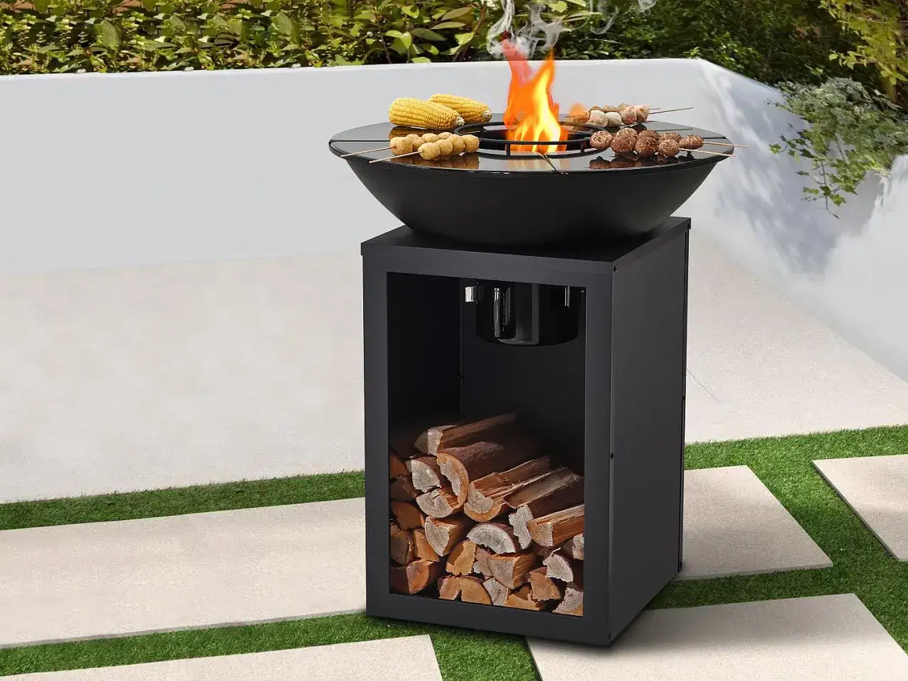 Barbecue moderne en extérieur, avec des brochettes et du maïs grillant sur le feu. Le compartiment inférieur est rempli de bois pour un barbecue bois ou charbon.