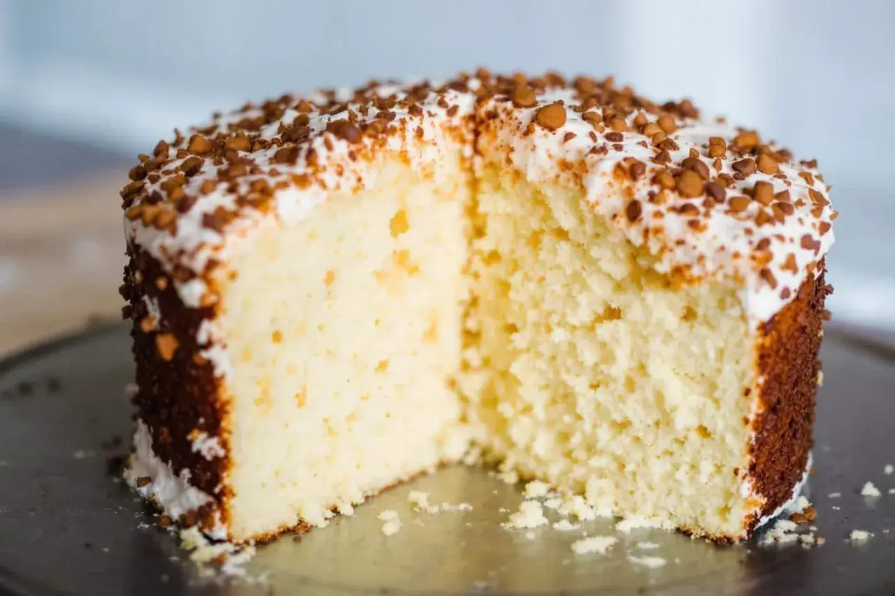 Gâteau à la crème, saupoudré de noisettes concassées. Sa texture dense me fait me demander : pourquoi mon gâteau ne gonfle pas ?