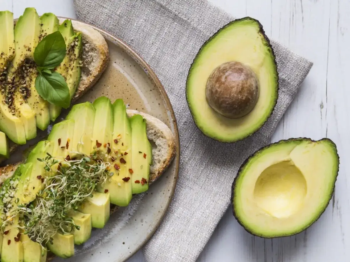 Tartines d'avocat, une recette simple et délicieuse. Avocat tranché sur pain grillé, garni de pousses et d'épices.