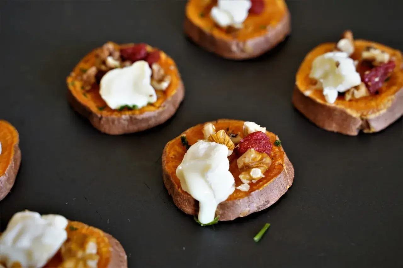 Rondes de patate douce garnies de fromage frais, noix et canneberges. Un délice pour un apéro patate douce original.