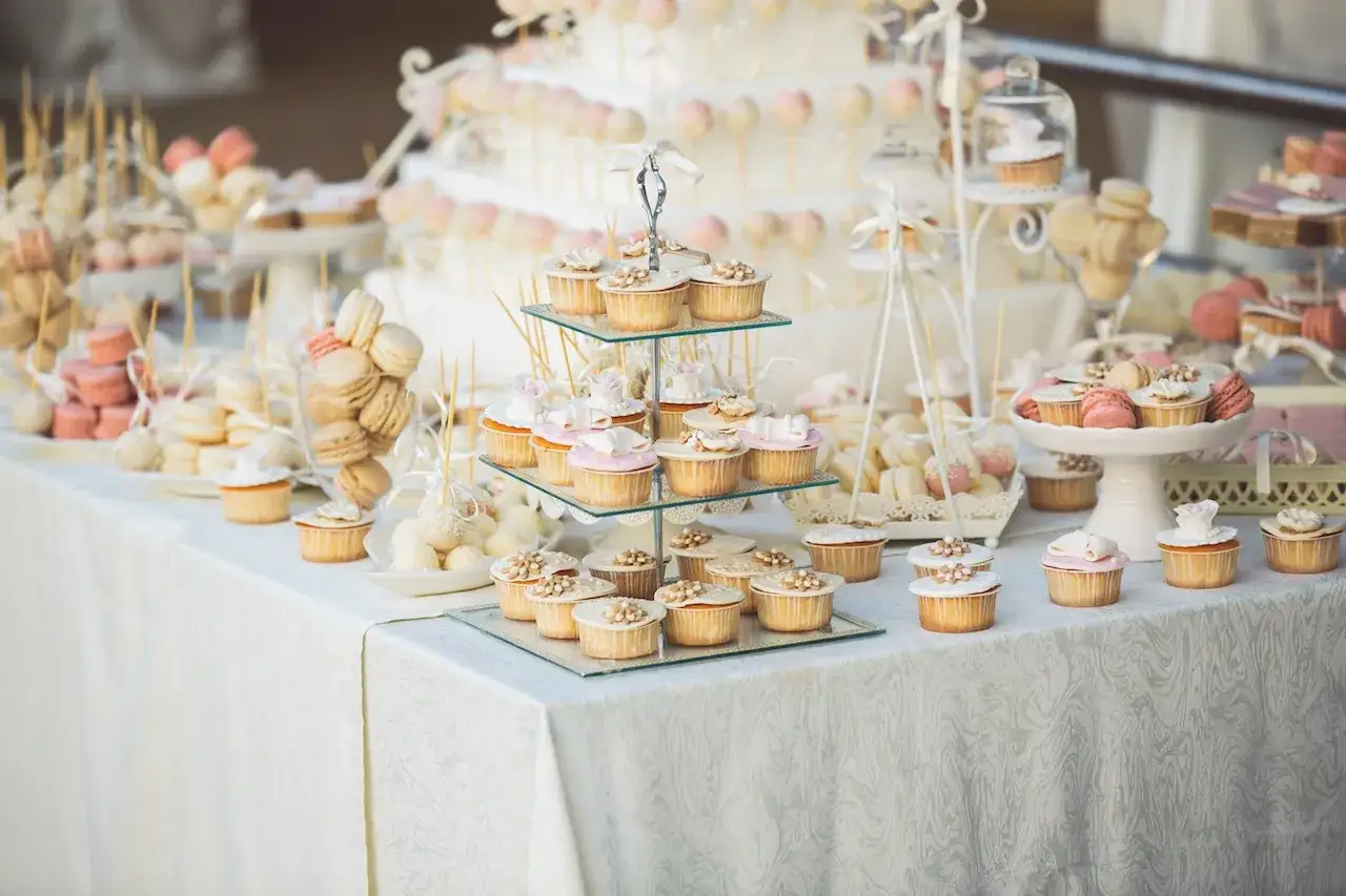 Un buffet de mariage féerique avec une idée buffet dessert mariage parfaite : cupcakes, macarons, cake pops et une pièce montée élégante.