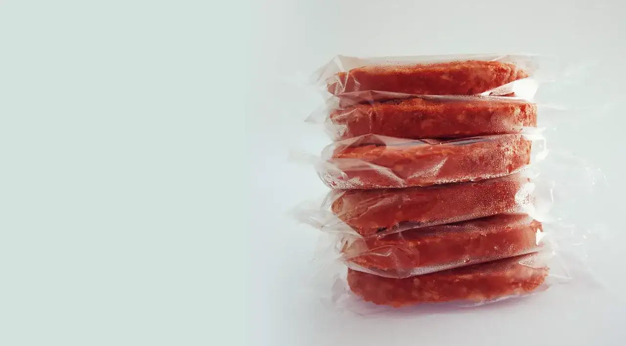 Pile de steaks hachés emballés sous vide, prêts pour la conservation de viande cuite barbecue.