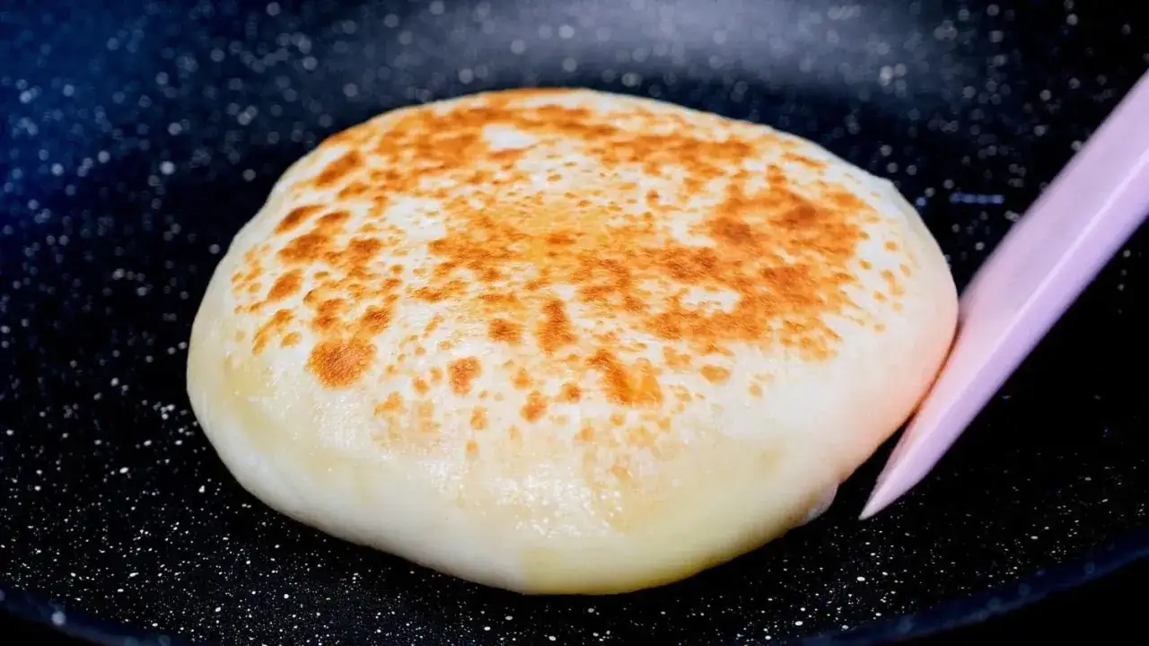 Galette de pomme de terre dorée, prête à être retournée dans la poêle. Une recette facile et rapide de pomme de terre sans four.