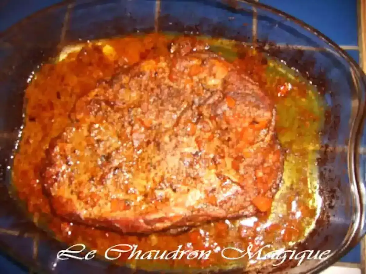 Rouelle de porc mijotant dans une sauce aux carottes et épices, prête à être dégustée. Une marinade savoureuse pour un plat réconfortant.