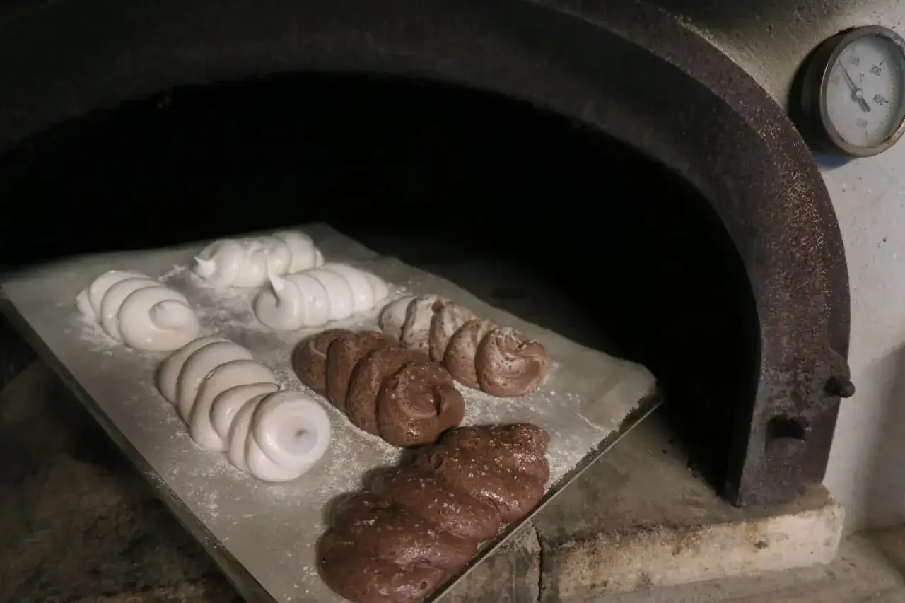 Douceurs meringuées et chocolatées prêtes à cuire dans un four à bois. Un vrai dessert au feu de bois en préparation.
