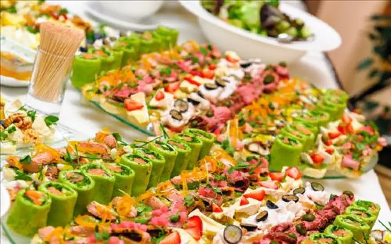 Buffet d'amuse-bouches variés, parfaits pour un mariage à faire soi-même. Rouleaux verts, garnitures colorées, fraises et olives.
