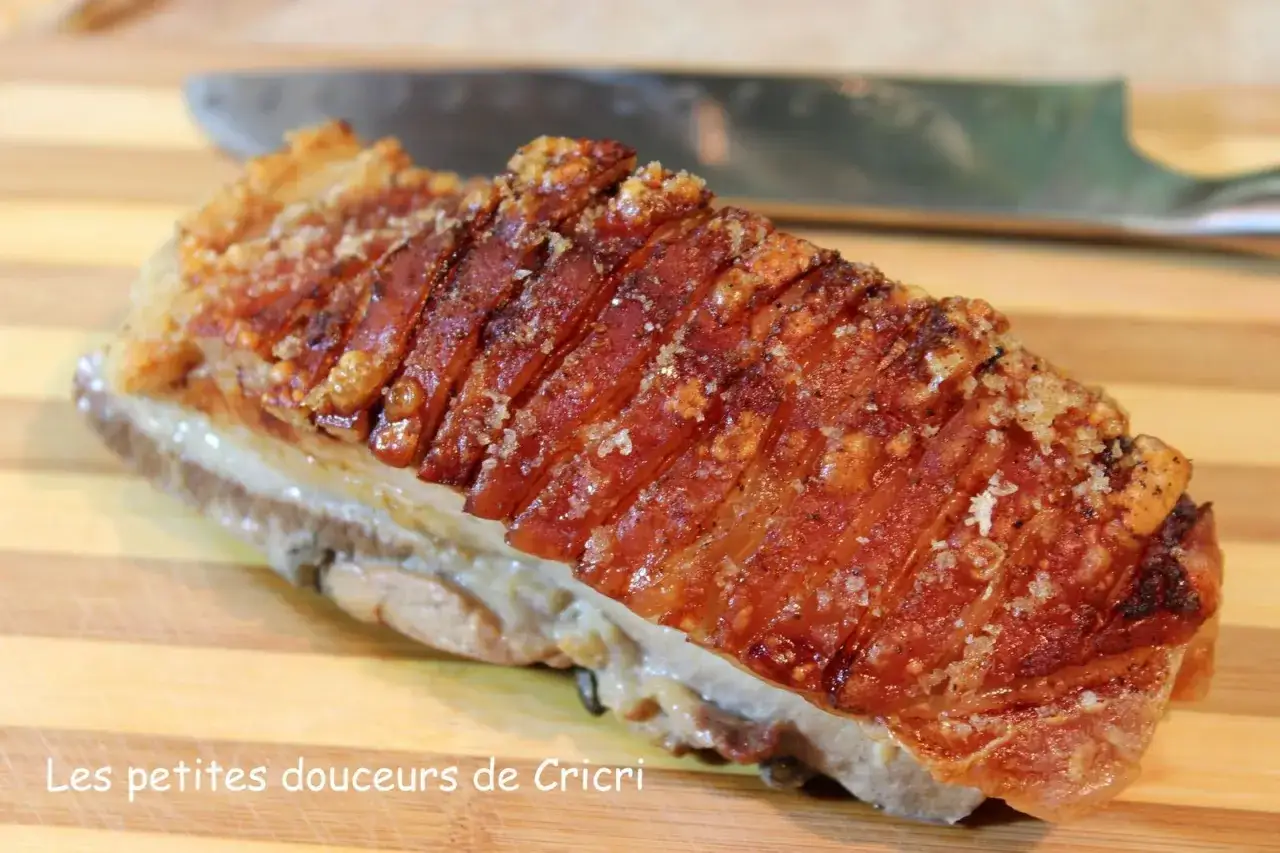 Un morceau de poitrine de porc au four cuisson lente, croustillant et doré, prêt à être dégusté.