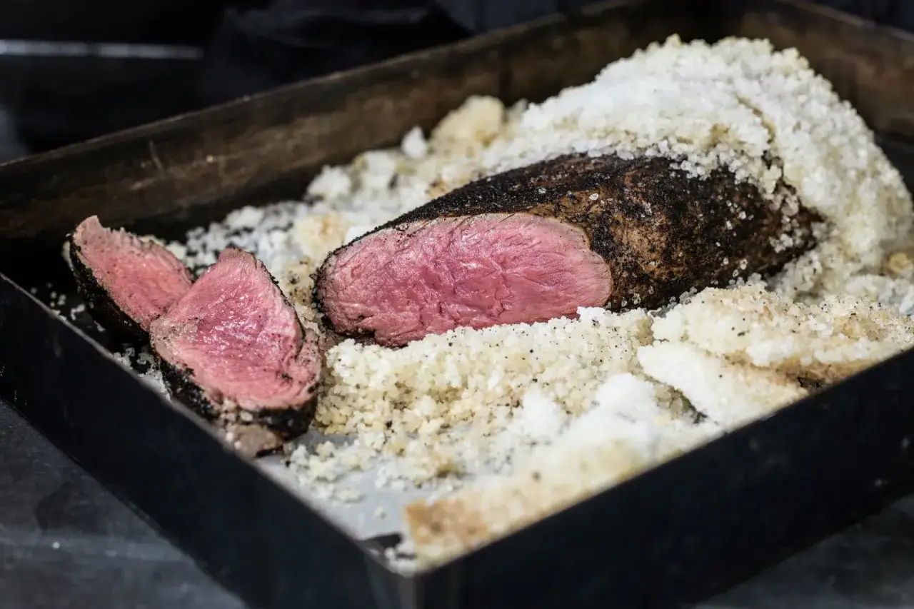 Un succulent côte de bœuf croute de sel, sa chair rosée et tendre, prête à être dégustée.