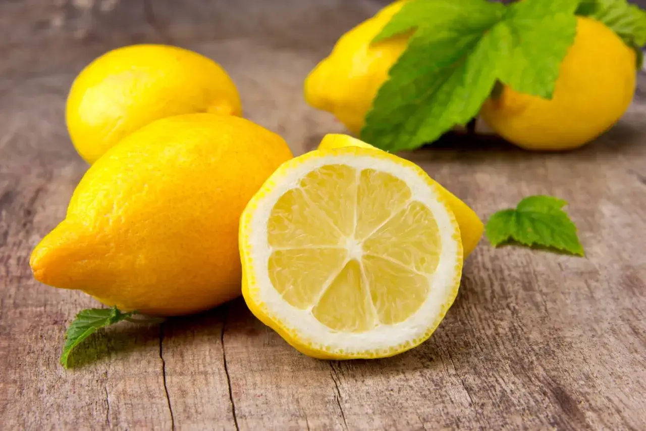 Citrons frais et menthe sur fond de bois, parfaits pour une recette avec citron rafraîchissante.