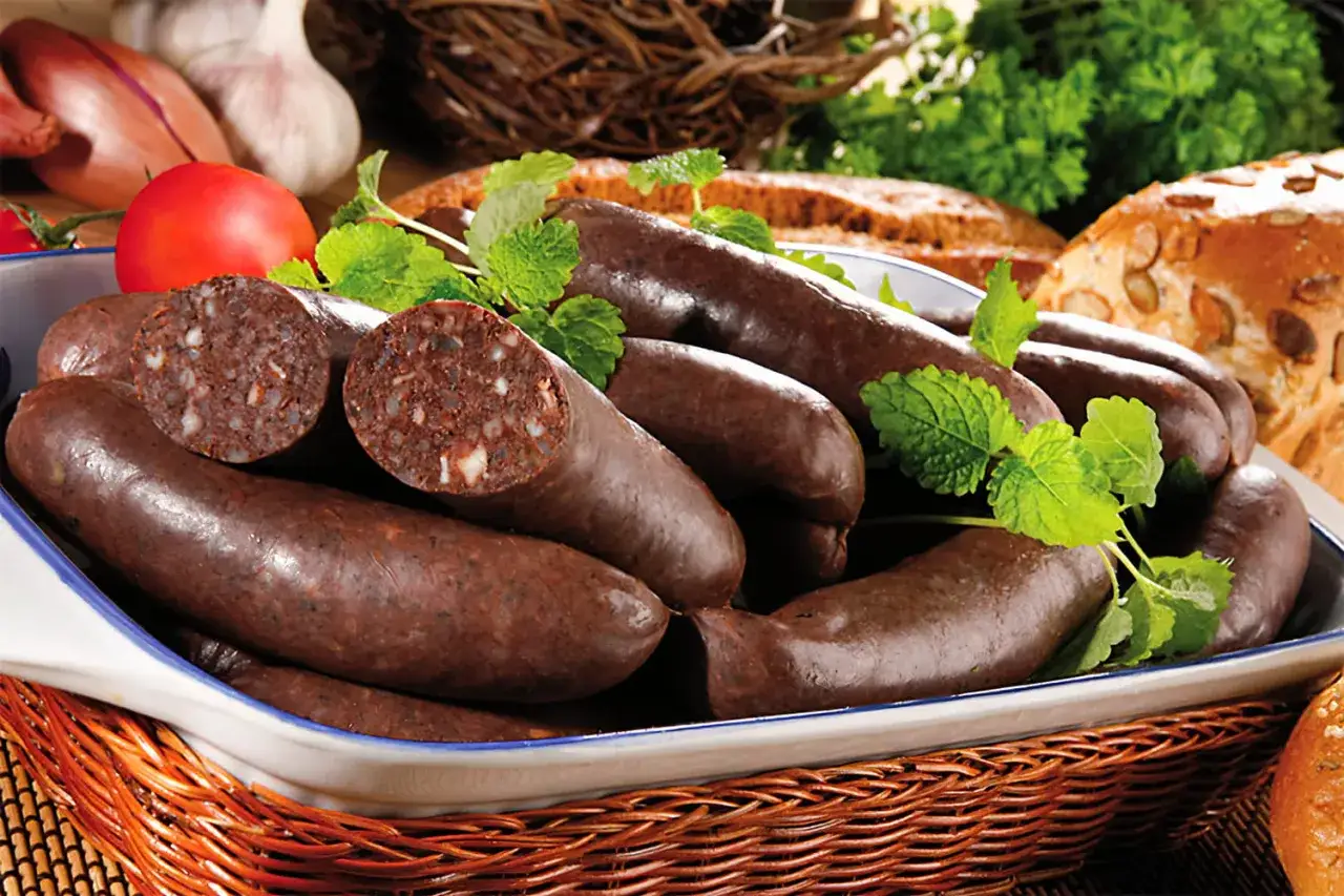 Boudin noir prêt à être cuit, avec des herbes fraîches. Le temps cuisson boudin est essentiel pour un plat savoureux.