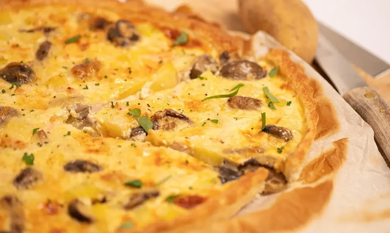 Une d&eacute;licieuse quiche poulet pomme de terre, garnie de champignons et d'herbes fra&icirc;ches, pr&ecirc;te &agrave; &ecirc;tre d&eacute;gust&eacute;e.